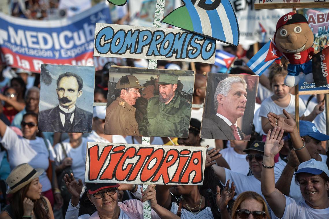 Participantes en el desfile del Día del Trabajo, el 1 de mayo del 2018, sostienen pancartas e imágenes del héroe nacional cubano, José Martí, los ex presidentes Raúl y Fidel Castro, así como el presidente Miguel Díaz-Canel, en la Plaza de la Revolución de La Habana.