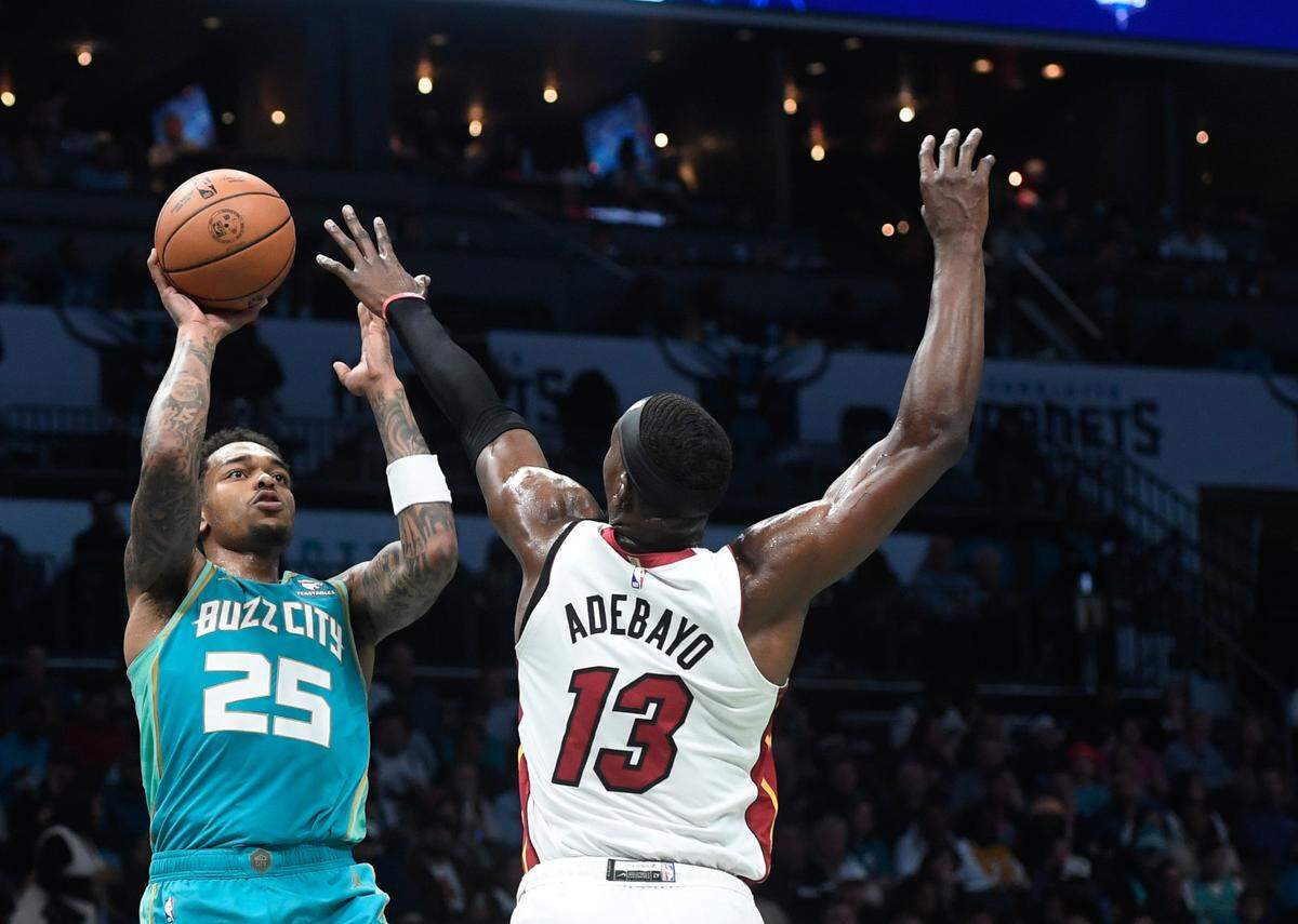 El jugador de los Hornets P.J. Washington Jr. tira al aro ante la marca de Bam Adebayo, del Heat de Miami, en el partido celebrado el 14 de noviembre de 2023 en Charlotte.