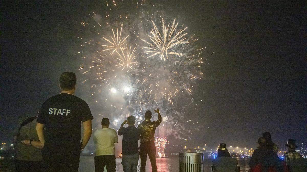 Algunas personas se detienen a mirar los fuegos artificiales en la Bahía de Biscayne durante la Nochevieja en Bayfront Park el 31 de diciembre de 2024.