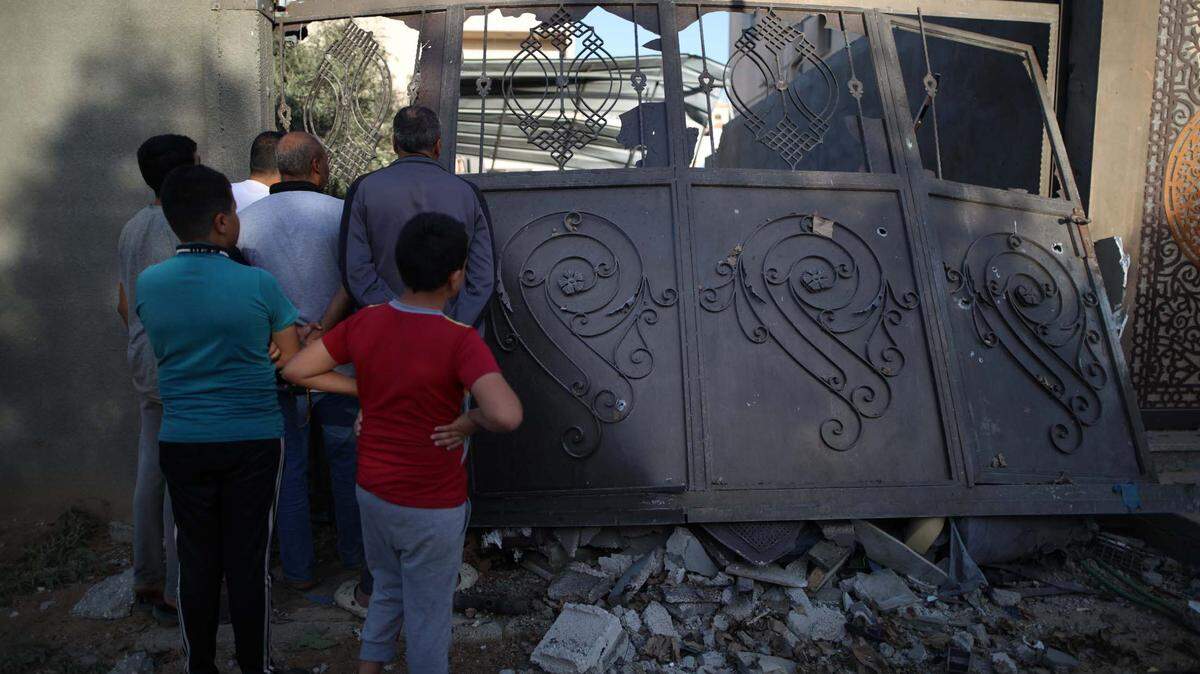 Palestinos se reúnen frente a un edificio destruido por un bombardeo israelí, en campo de refugiados Al Nuseirat, en la región central de Gaza, el lunes 28 de octubre de 2024.