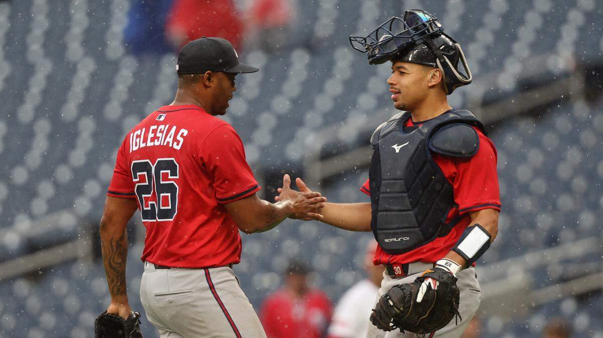 El cerrador de los Bravos de Atlanta Raisel Iglesias celebra con el receptor Drake Baldwin tras conseguir el juego salvado 250 de su carrera en Grandes Ligas, en el partido contra los Nacionales efectuado el 16 de septiembre de 2025 en Washington.