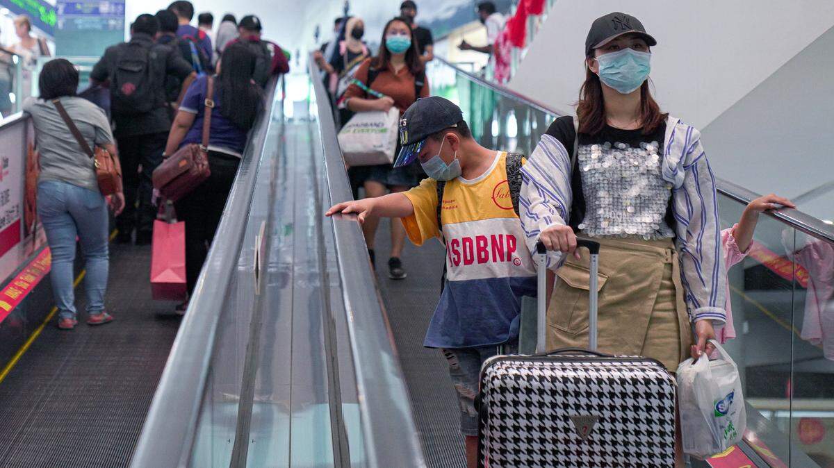 Pasajeros usan mascarillas de protección durante su tránsito por el Aeropuerto Internacional de Kuala Lumpur, Malasia, el martes 4 de febrero de 2020. 