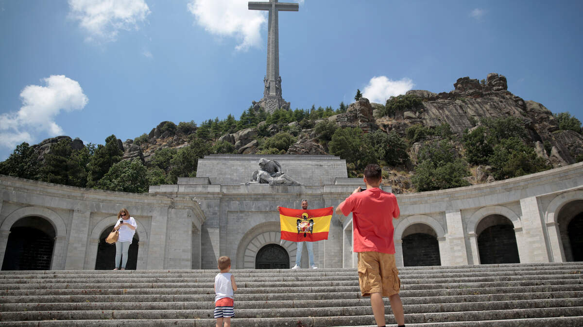 Una bandera española de antes de la Constitución ondea sobre el mausoleo del dictador español Francisco Franco en el Valle de los Caidos, cerca de El Escorial en las cercanías de Madrid. El nuevo gobierno de centroizquierda español dice que retirar el cuerpo embalsamado del general Francisco Franco de un glorificado mausoleo será la primera de una serie de medidas simbólicas que buscan reconciliar la turbulenta historia del país.