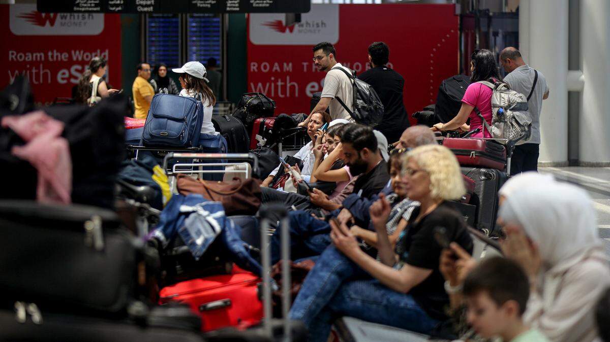 Una decena de pasajeros, la mayoría de ellos extranjeros, espera para abordar un avión y salir del Líbano, en el Aeropuerto de Beirut, el lunes 5 de agosto de 2024.