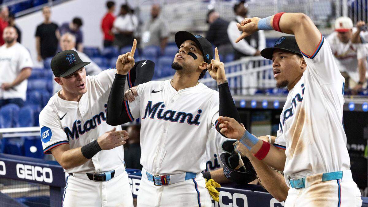 El pelotero de los Marlins Máximo Acosta (centro) celebra su primer jonrón en Grandes Ligas con sus compañeros de equipo Heriberto Hernández (der.) y Troy Johnston, en el noveno inning del partido ante los Cardenales de San Luis, efectuado el 20 de agosto de 2025 en Miami, Florida.
