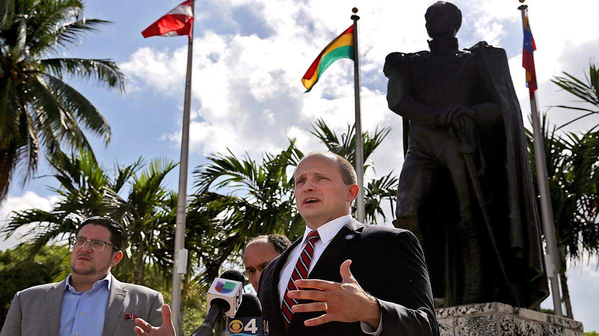 El senador José Javier Rodríguez, a la derecha, junto con el activista político José Hernández llaman al gobierno federal para que otorgue a la comunidad venezolana el TPS,  junto a la estatua de Simón Bolívar en el Parque Bayfront el martes 29 de agosto de 2017.