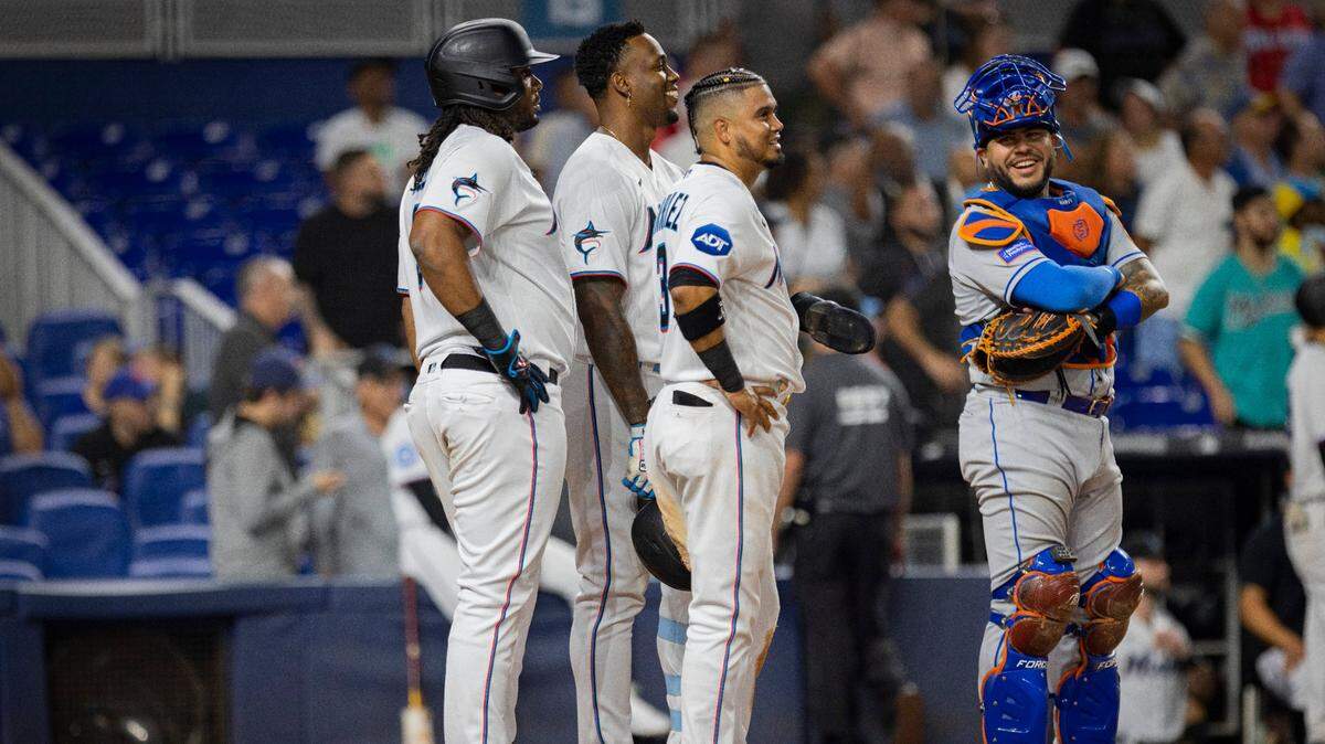 El pelotero de los Marlins Jorge Soler (centro) espera junto con Luis Arráez (der.) y Josh Bell la decisión de los árbitros tras pegar un batazo que primero fue declarado jonrón y luego foul, en el sexto inning del partido ante los Mets de Nueva York, celebrado el 18 de septiembre de 2023 en Miami.