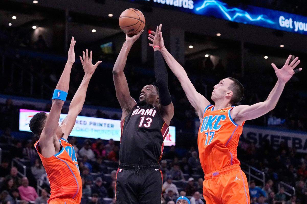 El centro del Heat de Miami Bam Adebayo tira al aro ante la marca de Darius Bazley (izq.) y Aleksej Pokusevski, del Thunder, en el partido celebrado el 14 de diciembre de 2022 en Oklahoma.