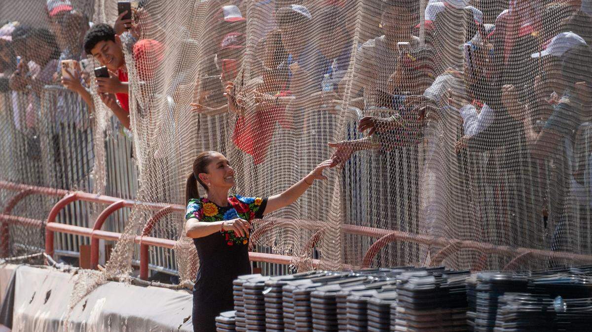 Mexican President Claudia Sheinbaum shakes hands with supporters as she arrives at Estadio de Beisbol Juárez Vive in Ciudad Juárez, Mexico, on Thursday, Sept. 26, 2025, followed by Chihuahua Gov. María Eugenia Campos. Sheinbaum is touring all 32 states as part of her first annual address since taking office.