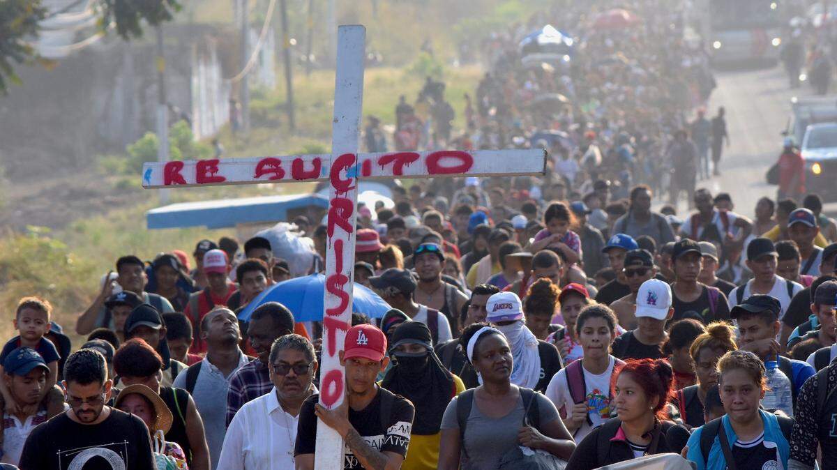 Migrantes que caminan por la carretera llevan una cruz que dice en español “Cristo Resucitado” durante la Semana Santa mientras avanzan por Tapachula en el estado mexicano de Chiapas, el lunes 25 de marzo de 2024.