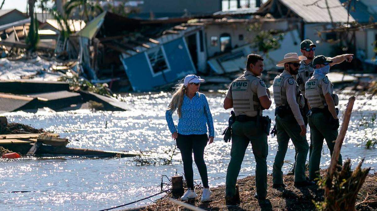 Funcionarios de la Comisión de Pesca y Conservación de la Vida Silvestre de la Florida (FWC) observan los daños en Matlacha tras el paso del huracán Ian.