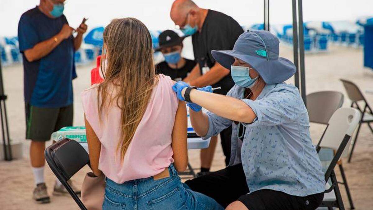 Una persona recibiendo una vacuna de Johnson & Johnson por parte de un trabajador de la salud en un sitio de vacunación emergente ubicado en la playa de 16th Street el domingo 2 de mayo de 2021, en Miami Beach.