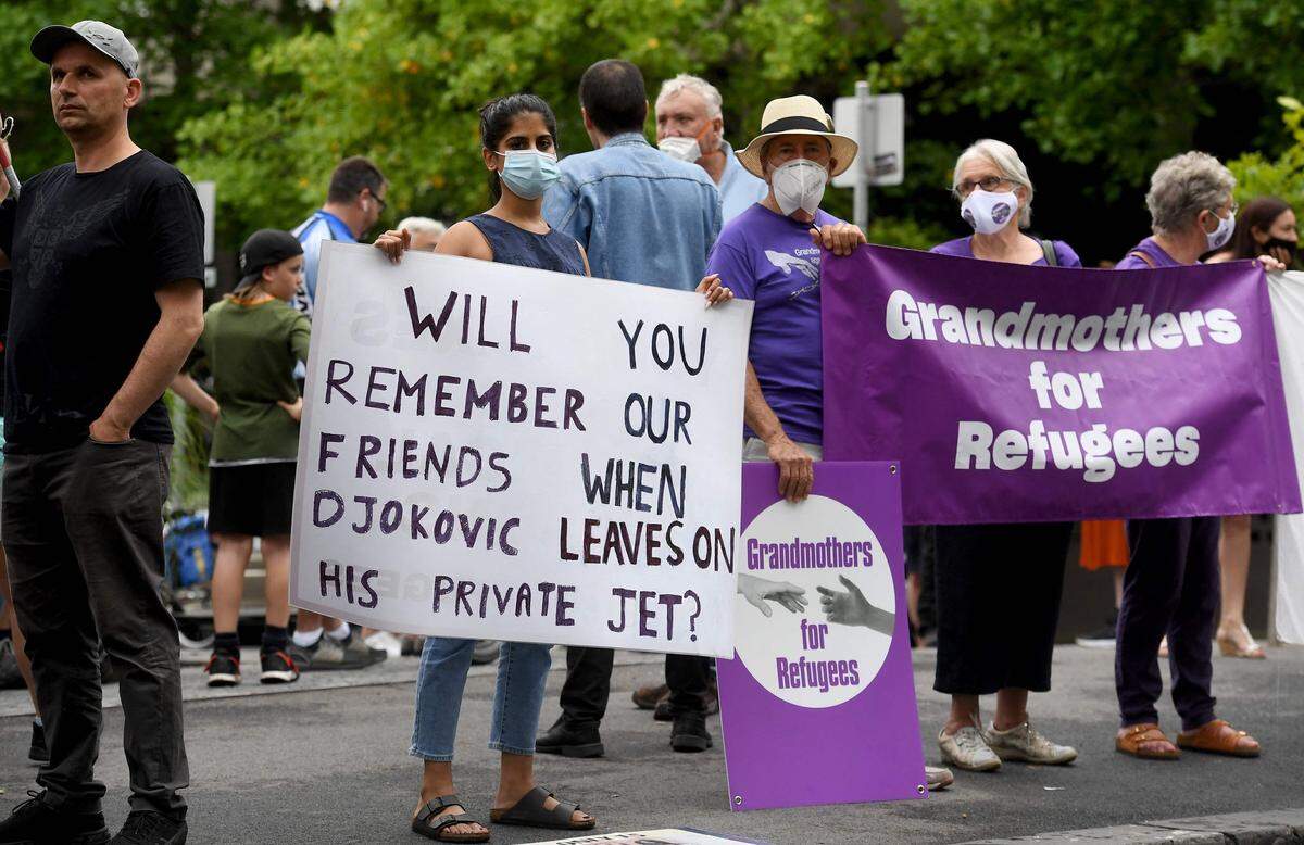 Un grupo de personas portan carteles en un centro de detención del gobierno donde se encuentra Novak Djokovic, el 7 de enero de 2022 en Melborune, Australia.