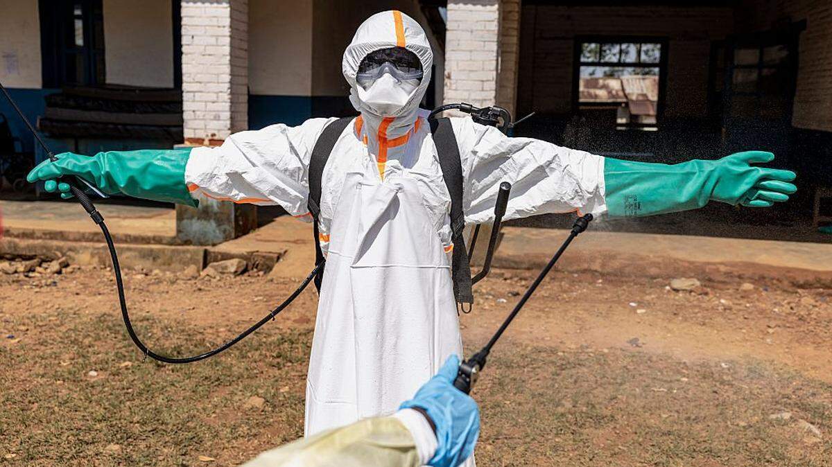 Un trabajador sanitario, ataviado con equipo de protección, es desinfectado a las afueras de una sala de aislamiento en el Hospital General de Mongbwalu durante el brote de ébola, el 22 de mayo de 2026, en Mongbwalu, República Democrática del Congo. La Organización Mundial de la Salud (OMS) ha declarado el brote de ébola en la República Democrática del Congo (RDC) y Uganda como una “emergencia de salud pública de importancia internacional”, a medida que el número de fallecimientos y de casos confirmados continúa en aumento.