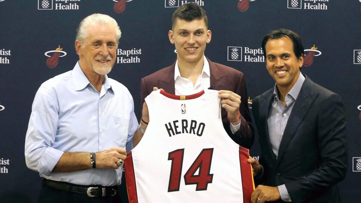 Tyler Herro posa con el número 14 entre el presidente Pat Riley y el coach Erik Spoelstra (der.), tras ser presentado este viernes por el Heat AmericanAirlines Arena.