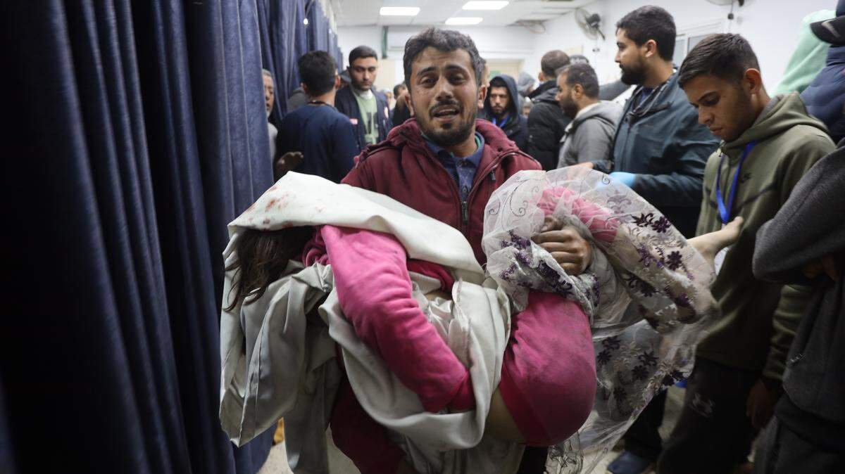 Un hombre palestino carga a un niño herido en un bombardeo israelí, en el Hospital Al-Ahli en Ciudad Gaza, el miércoles 19 de diciembre de 2024.