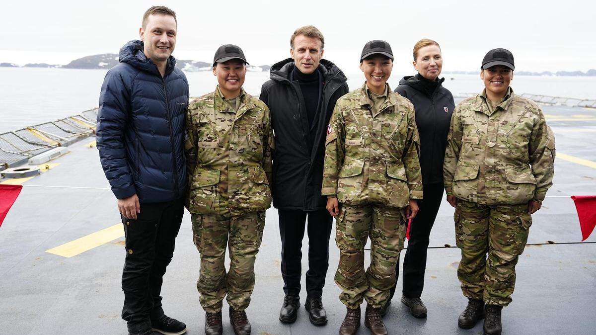 El presidente francés, Emmanuel Macron (3-i), la primera ministra danesa, Mette Frederiksen (2-d), y el líder groenlandés, Jens-Frederik Nielsen (i), posan con soldados a bordo de la fragata danesa F363 Niels Juel en Nuuk, Groenlandia, el domingo 15 de junio de 2025.