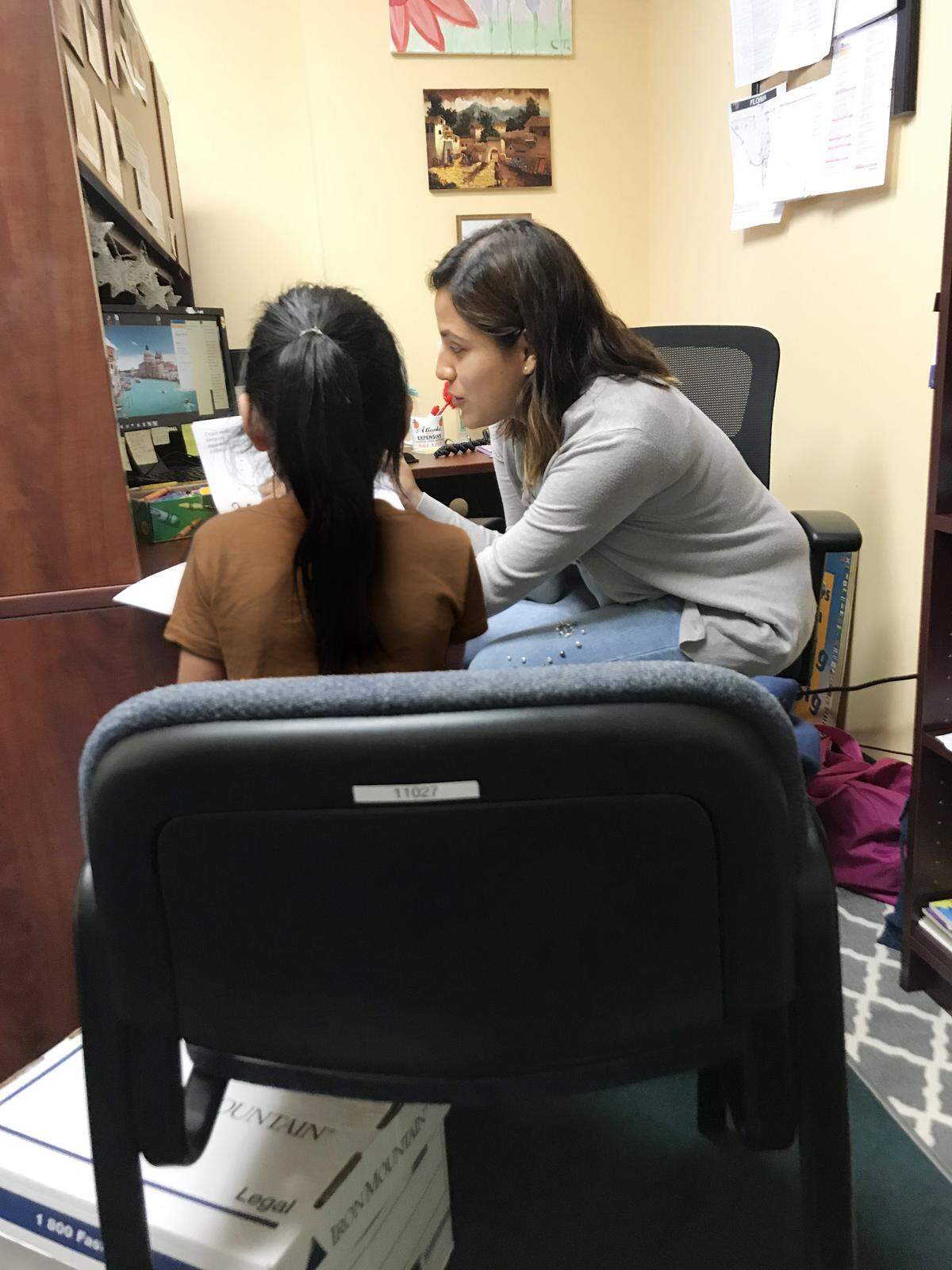 La asistente legal  Cindy Torres conversa con uno de los niños inmigrantes representadnos legalmente por Americans for Immigrant Justice (AIJ).