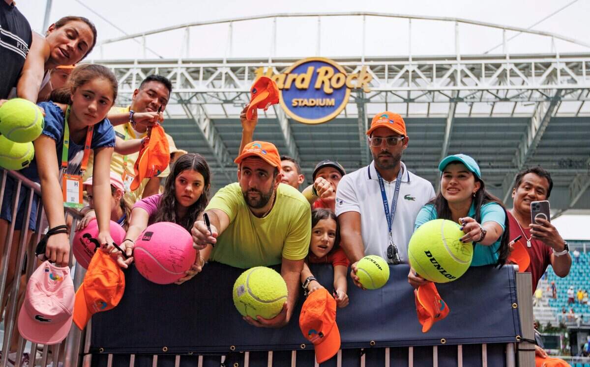 Un grupo de fanáticos espera para que Carlos Alcaraz les firme un autógrafo, el 3 de abril de 2022 en el Hard Rock Stadium en Miami Gardens, Florida.
