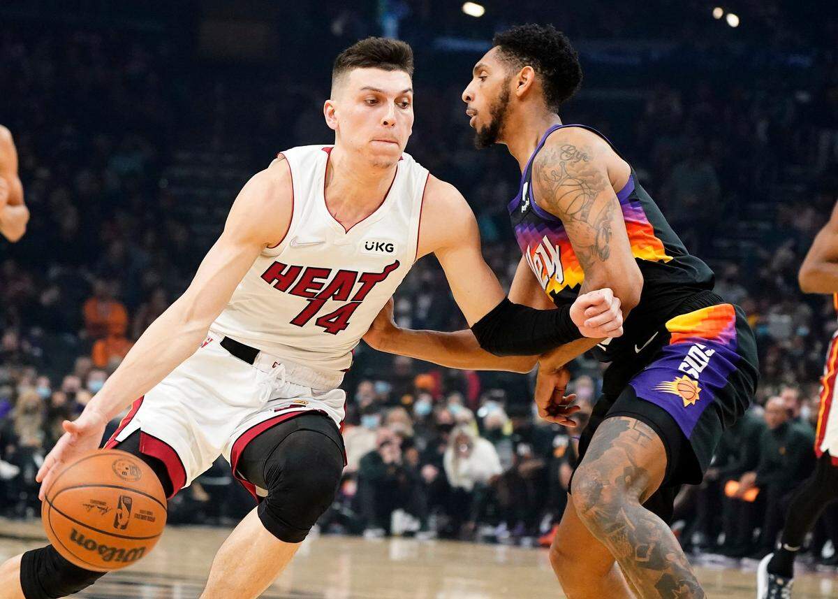 El jugador del Heat Tyler Herro (14) trata de pasar la marca de Cameron Payne, de los Suns, en el partido celebrado el 8 de enero de 2022 en Phoenix.