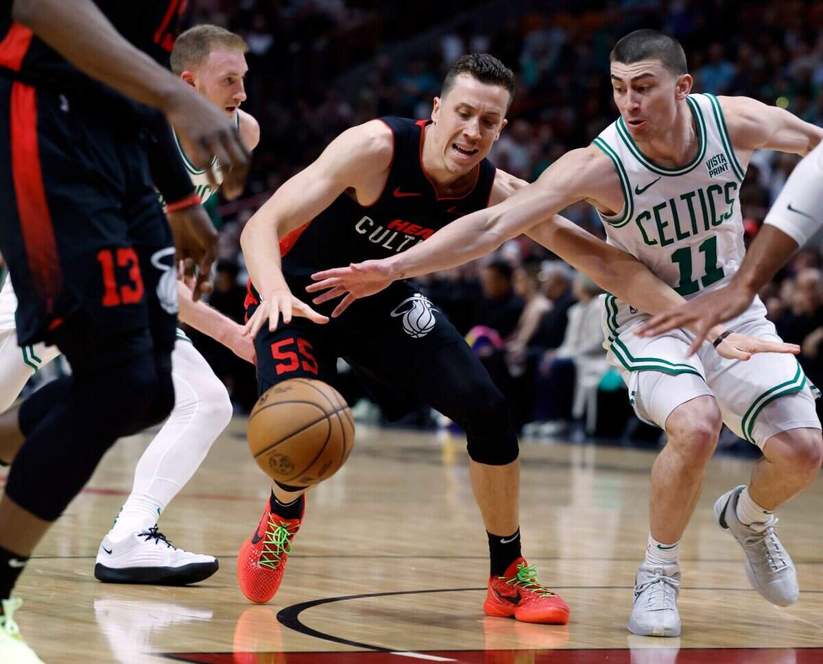 El jugador del Heat Duncan Robinson (centro) lucha por la pelota con Payton Pritchard (11), de los Celtics de Boston, en el partido celebrado el 25 de enero de 2024 en Kaseya Center en Miami, Florida.