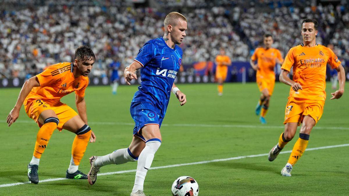 El jugador del Chelsea Mykhaylo Mudryk conduce la pelota ante la marca de Raúl Asencio (izq.) y Lucas Vázquez, del Real Madrid, en el partido celebrado el 6 de agosto de 2024 en Charlotte, Estados Unidos.