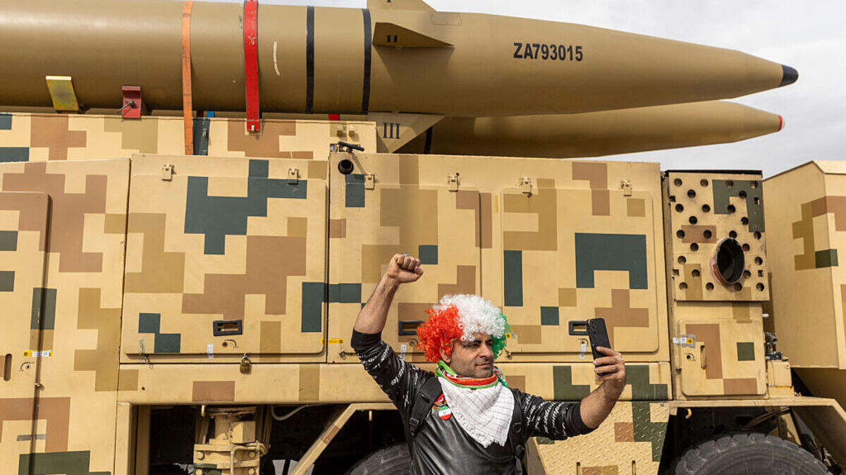 Un participante iraní con peluca se toma una foto con un misil exhibido producido por las fuerzas armadas de Irán durante las conmemoraciones para conmemorar el aniversario de la Revolución iraní de 1979, el miércoles 11 de febrero de 2026 en Teherán, Irán.