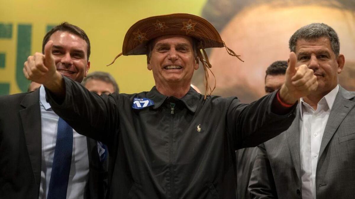 El candidato presidencial de Brasil, Jair Bolsonaro, flanqueados por su hijo y el senador electo de Río de Janeiro, Flavio Bolsonaro durante una conferencia de prensa en Río de Janeiro.