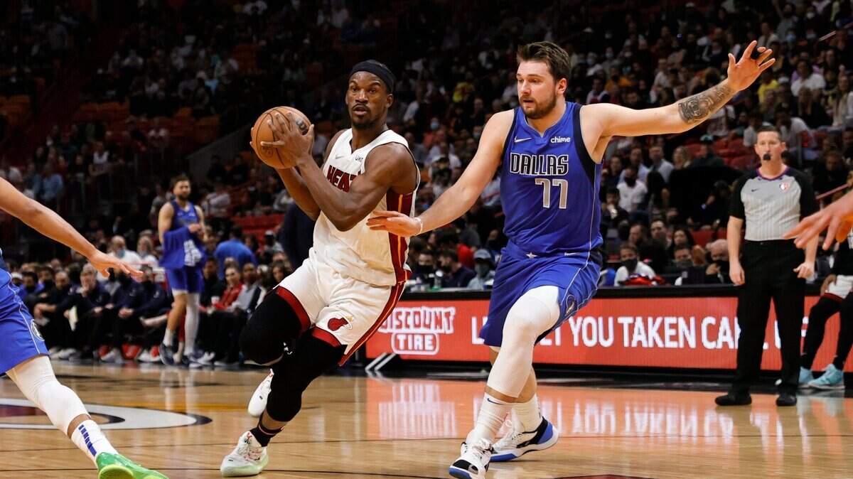 El jugador del Heat Jimmy Butler (izq.) entra al aro ante la marca de Luka Doncic, de los Mavericks de Dallas, en el partido celebrado el 15 de febrero de 2022 en Miami.