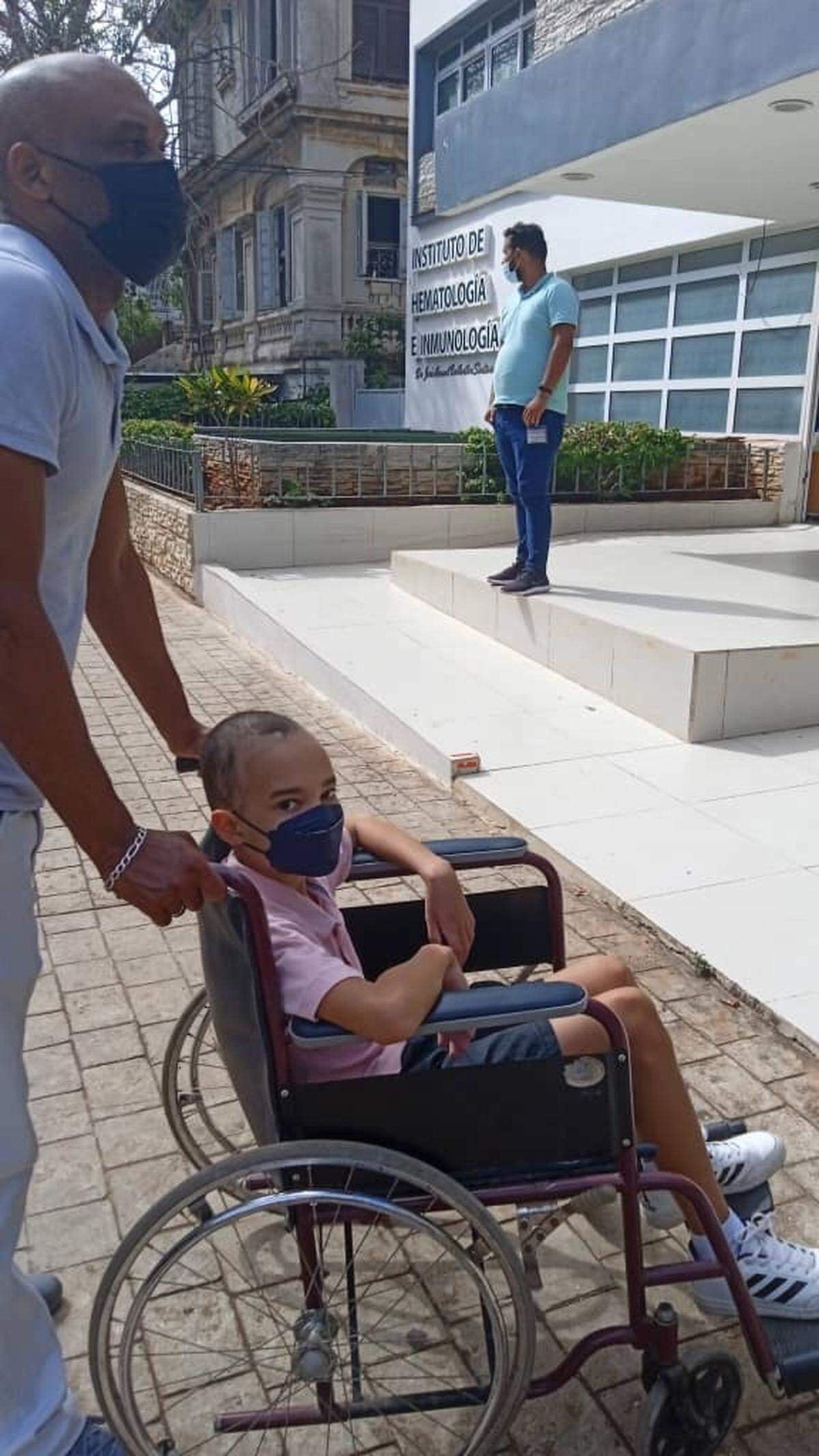Jesús Cateura Cateura, de 45 años, dirige la silla de ruedas de su hijo José Camilo Cateura Díaz, de 11 años, hacia la entrada del Instituto de Hematología e Inmunología en La Habana, Cuba.