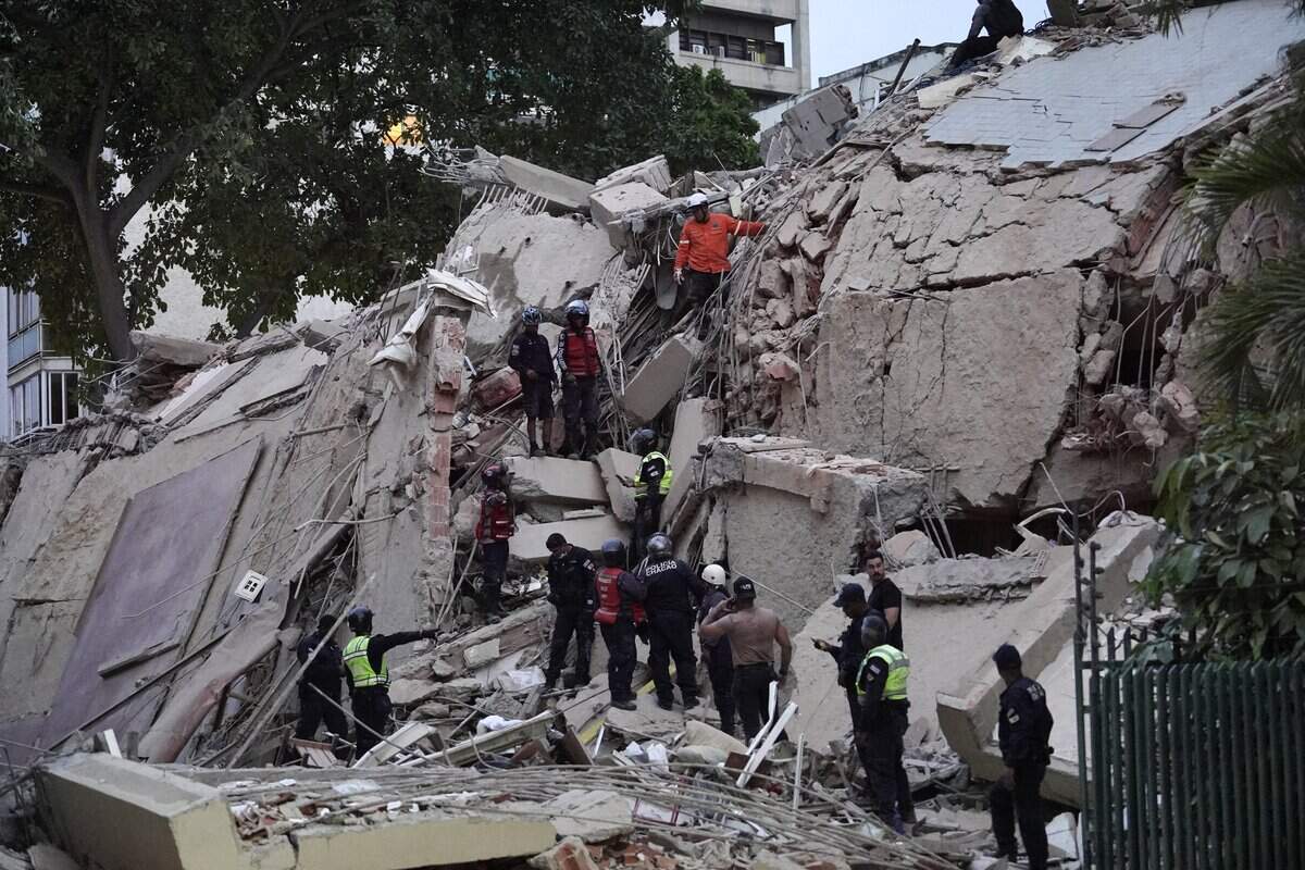 TOPSHOT - Rescuers search for victims in a collapsed building following an earthquake in Caracas on June 24, 2026. Two earthquakes of magnitude 7.2 and 7.5 struck the same area of Venezuela on the evening of June 24, causing buildings to collapse, according to the United States Geological Survey (USGS) and AFP journalists. The quakes drove residents of the capital, Caracas, into the streets. (Photo by Manaure Quintero / AFP via Getty Images)