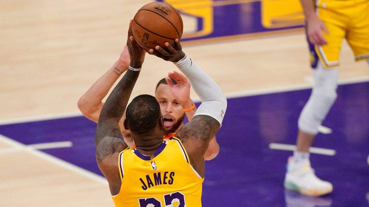 El delantero de los Lakers LeBron James,dispara sobre Stephen Curry, de los Warriors, y anota la canasta del triunfo en el juego de play -In entre ambos equipos, el miércoles 19 de mayo de 2021 en Los Ángeles.