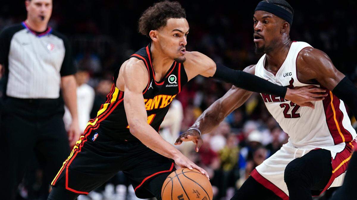 Atlanta Hawks guard Trae Young, front left, drives against Miami Heat forward Jimmy Butler (22) in the first half of an NBA playoff basketball game Sunday, April 24, 2022, in Atlanta. (AP Photo/John Bazemore)