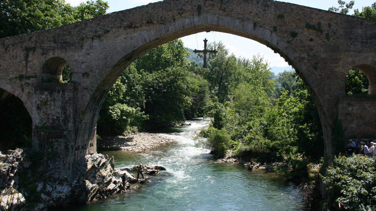 En Cangas de Onís una Cruz de la Victoria cuelga del Puente Romano.
