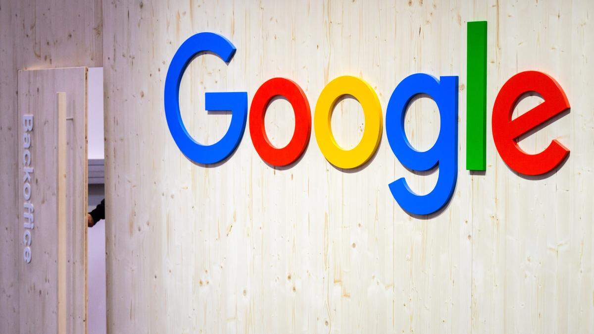 Un empleado cierra la puerta de la oficina administrativa junto a un logotipo de Google en el stand de Google en Hannover Messe 2024.