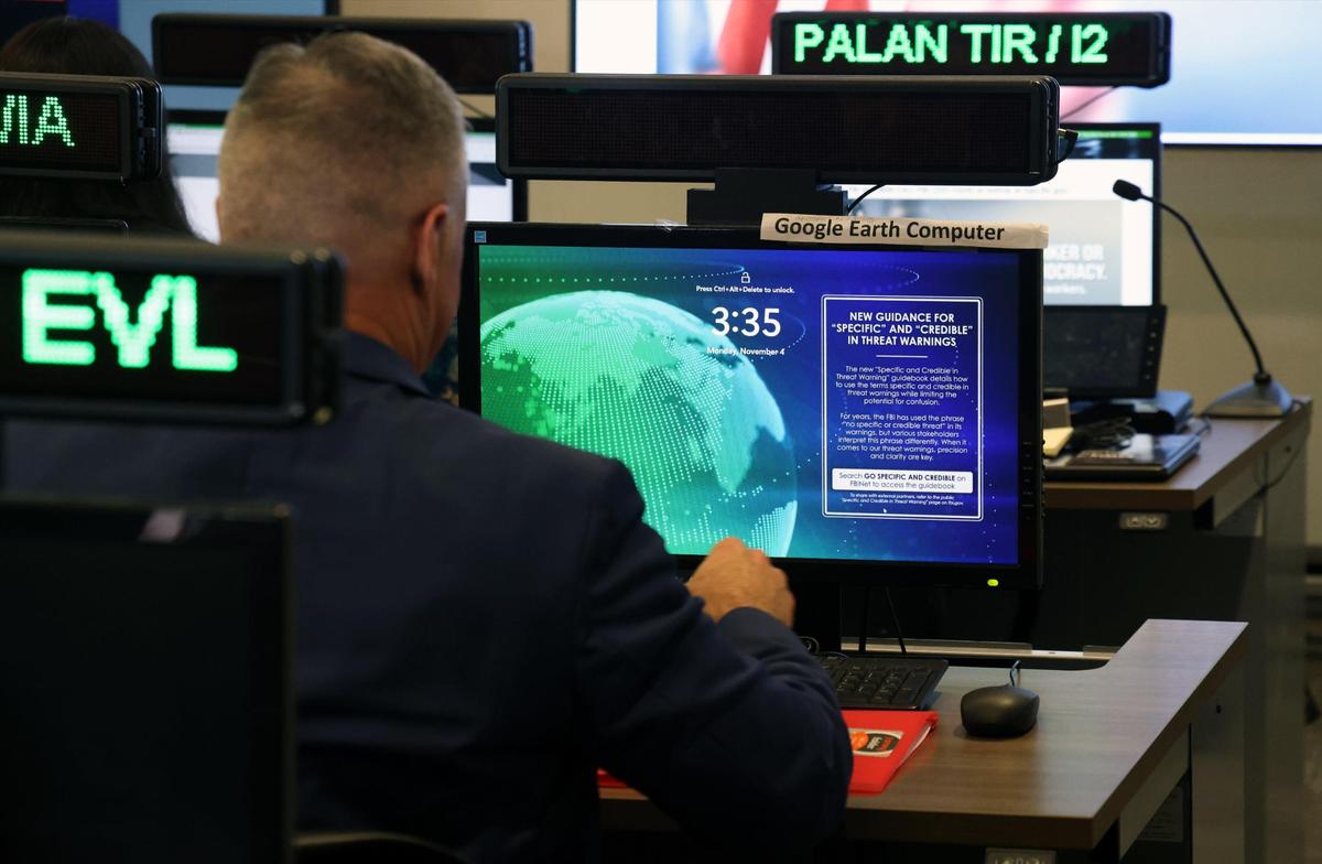 Miembros del grupo de trabajo sobre amenazas electorales, una colaboración entre el Departamento de Justicia y el FBI, operan el puesto de mando contra delitos electorales en la oficina de campo del FBI en Miami, en Miramar, Florida, el lunes 4 de noviembre de 2024.