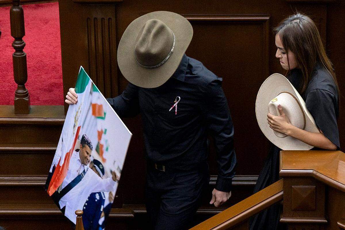 The widow of the late Mayor Carlos Manzo, Grecia Quiroz, accompanied by state representative Carlos Tafolla, leaves the podium at the Michoacan State Congress after being sworn in as Mayor of Uruapan in Morelia, Michoacan State, Mexico on November 5, 2025. The Mexican government reported on November 2 that the mayor of Uruapan, Carlos Manzo, who was killed the previous night during a public event in the western state of Michoacan, had been under official protection since December last year. (Photo by Enrique Castro / AFP) (Photo by ENRIQUE CASTRO/AFP via Getty Images)