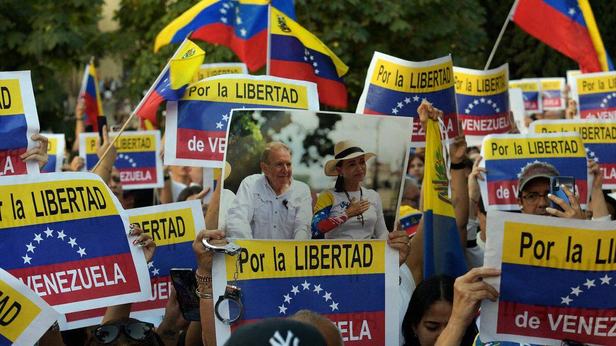 Una persona sostiene una fotografía del candidato presidencial opositor venezolano Edmundo González y de la líder opositora venezolana María Corina Machado, mientras venezolanos residentes en España participan en una manifestación frente al parlamento español en apoyo del candidato presidencial opositor Edmundo González, tras las disputadas elecciones venezolanas, en Madrid, España, el 10 de septiembre de 2024.