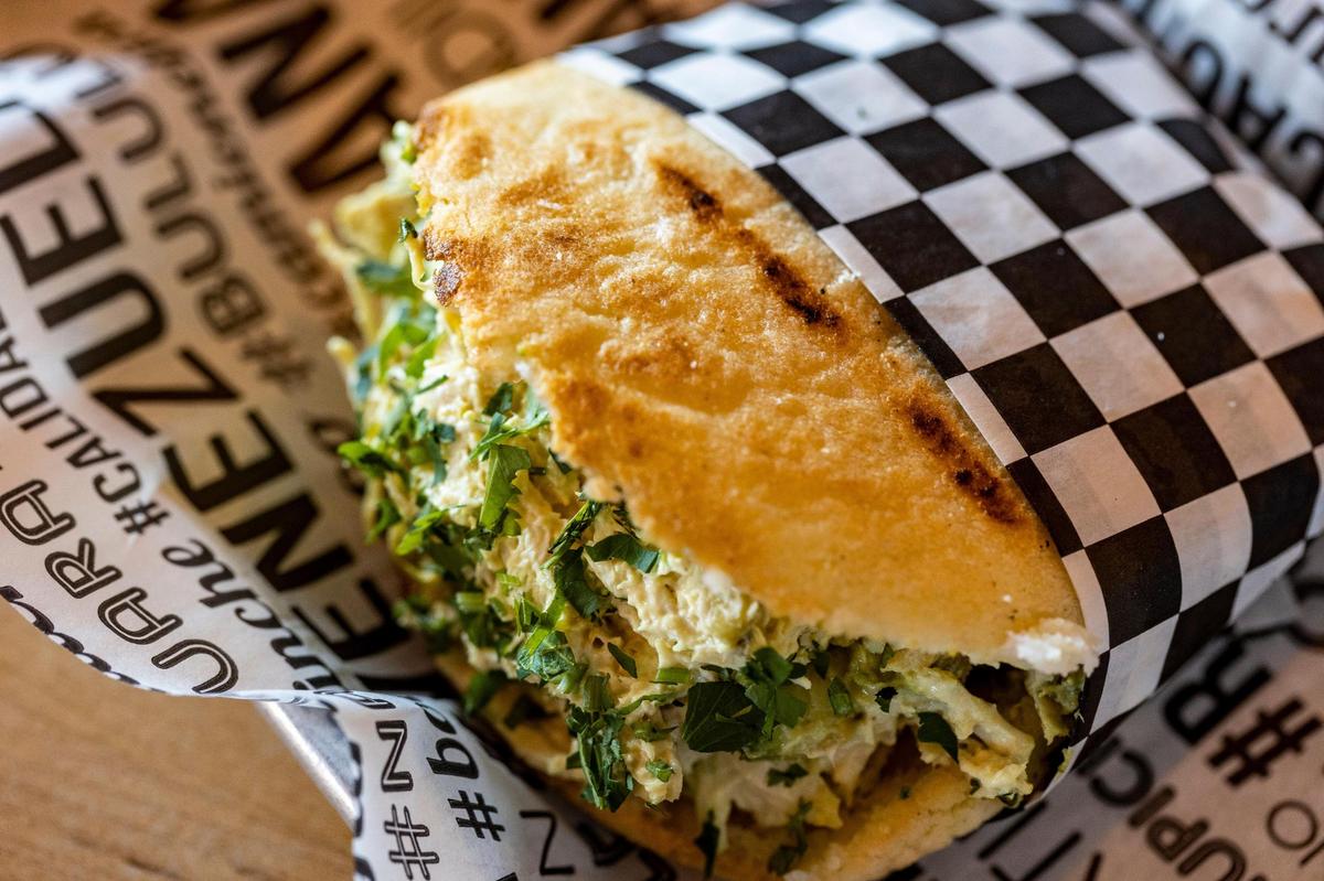 Arepa Reina Pepiada - Ensalada de pollo, aguacate, guisantes verdes y perejil picado en salsa de mayonesa y mostaza en Doggi’s Arepa Bar, 7281 Biscayne Blvd, Miami, FL 33138