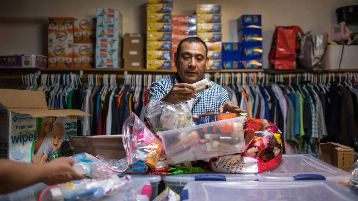 Sergio Cordova prepara bolsas con comida, productos higiénicos y otras necesidades para llevarlos y distribuirlos entre los migrantes que se encuentran cerca de una estación de autobuses en Brownsville, Texas.