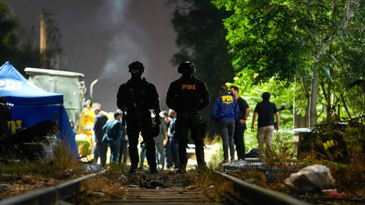 Agentes policiales y especialistas forenses investigan el área donde encontraron el cuerpo del exmilitar venezolano Ronald Ojeda, el viernes 1 de marzo de 2024, en las afueras de Santiago de Chile.