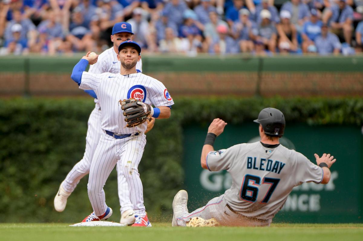 El segunda base de los Cachorros Nick Madrigal tira a la inicial en un jugada de doble matanza en el primer inning del partido ante los Marlins de Miami, celebrado el 8 de agosto de 2022 en Chicago.
