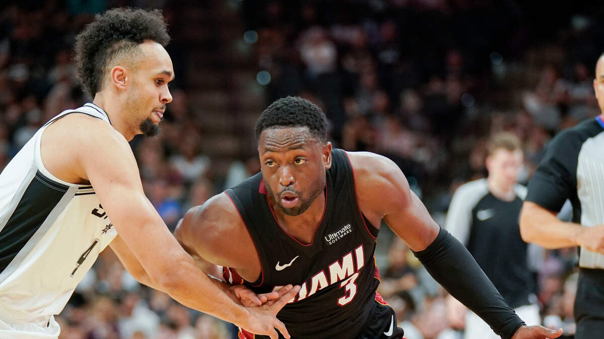 Dwyane Wade (der.) entra al aro por el Heat ante la marca de Derrick White, de los Spurs, el 30 de septiembre de 2018 en San Antonio.
