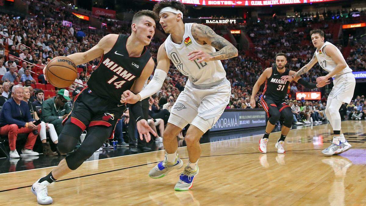 El escolta del Miami Heat, Tyler Herro (14), empuja hacia la canasta mientras el alero del Oklahoma City Thunder, Lindy Waters III (12), defiende en la primera mitad en el FTX Arena de Miami el viernes 18 de marzo de 2022.