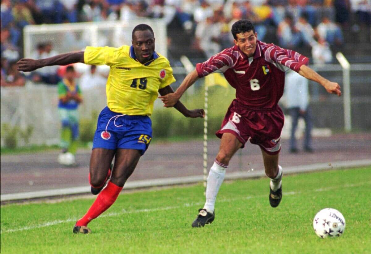 Foto de archivo. El colombiano Freddy Rincón (izq.) lucha por la pelota con Elvis Martínez, de Venezuela, en el partido clasificatorio para el Mundial de Francia, el 15 de diciembre de 1996.