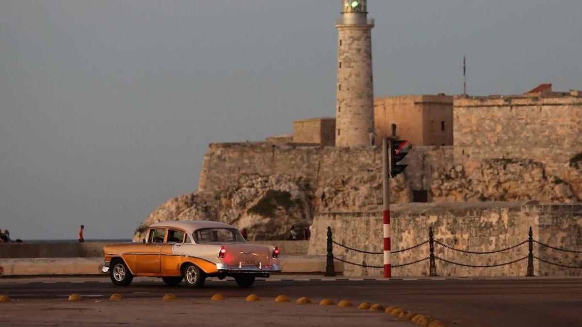 Con el Castillo San Felipe del Morro en el fondo, un viejo automóvil estadounidenses se ve a lo largo del Paseo del Prado en el barrio Habana Vieja el 21 de enero 2015 en La Habana, Cuba.