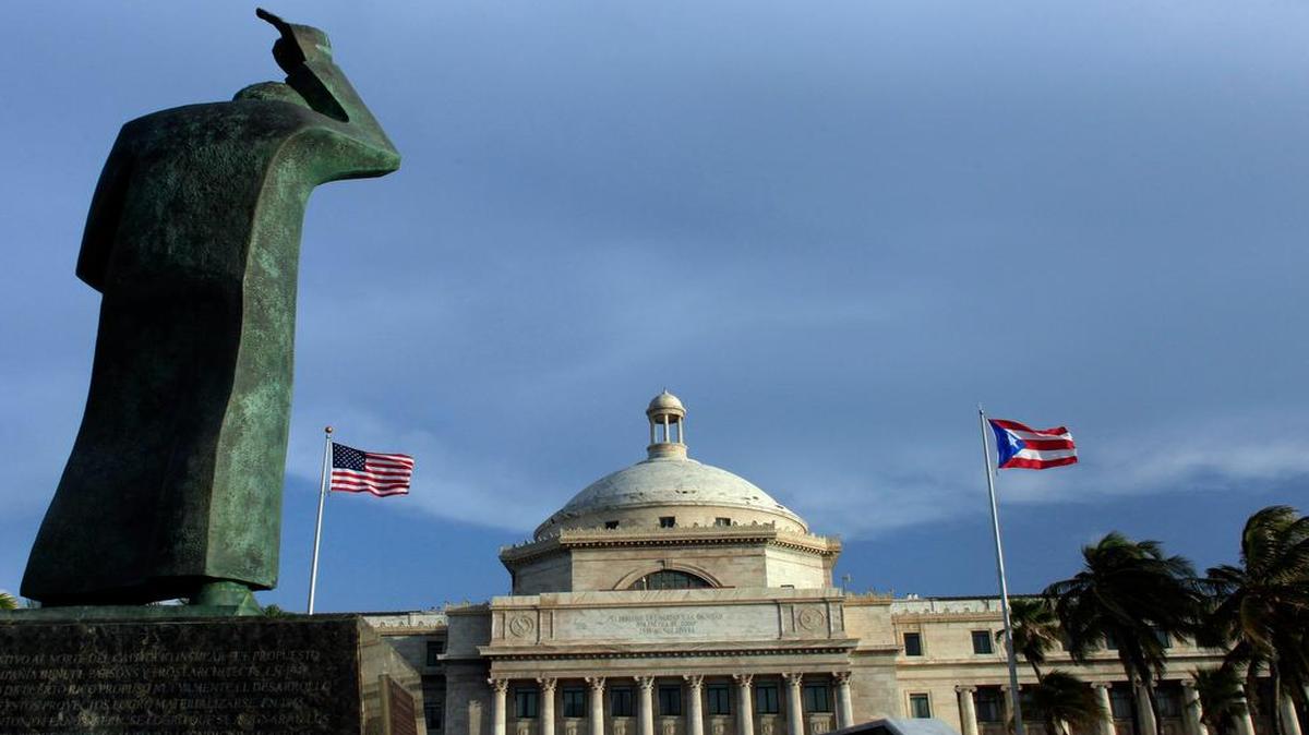 
Una estatua de San Juan Bautista mira hacia la entrada del Capitolio de Puerto Rico. En 62 años de autogobernación, Puerto Rico se ha endeudado externamente por $73 mil millones, más que el producto bruto (PBI) anual de la isla
