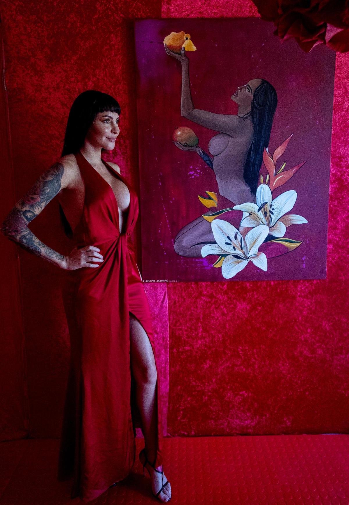 Miami, Florida, October 6, 2022 - Camimi Palomeque, an artist from Ecuador, stands next to one of her paintings on display at the Chakras Garden exhibit. The Chakras Garden (Jardin de Chakras) is an immersive artistic experience developed by seven artists from different parts of the world, creating a unique work of art that represents the seven main chakras, through different spaces converted into a garden of colors, shapes and textures.