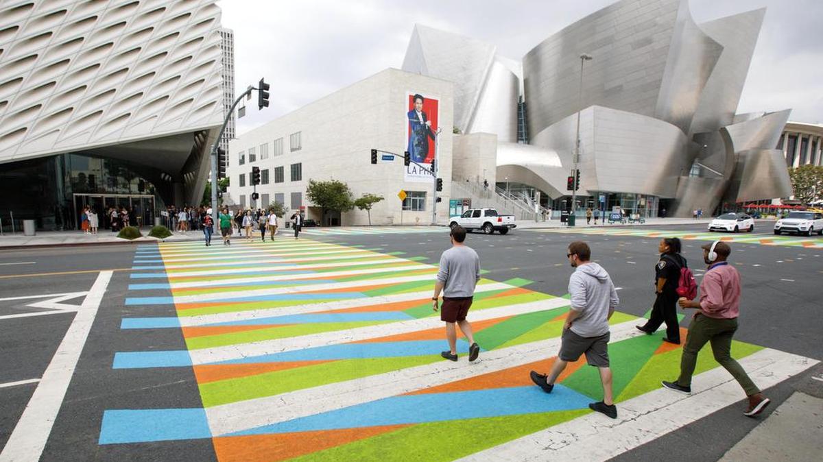 Peatones cruzan sobre una instalación artística del artista venezolano Carlos Cruz-Diez, como parte de la exposición Pacific Standard Time: LA/LA, afuera del museo Broad y la sala de conciertos Walt Disney en Los Ángeles, California, el martes 19 de septiembre de 2017.
