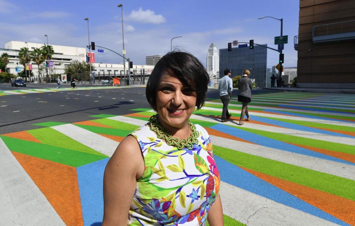 Adriana Cruz-Diez, hija del artista venezolano Carlos Cruz-Diez, posa junto a la obra de su padre que adorna el paso peatonal afuera del museo Broad y la sala de conciertos Walt Disney en Los Ángeles, California. La obra es parte de la exposición Pacific Standard Time: LA/LA.
